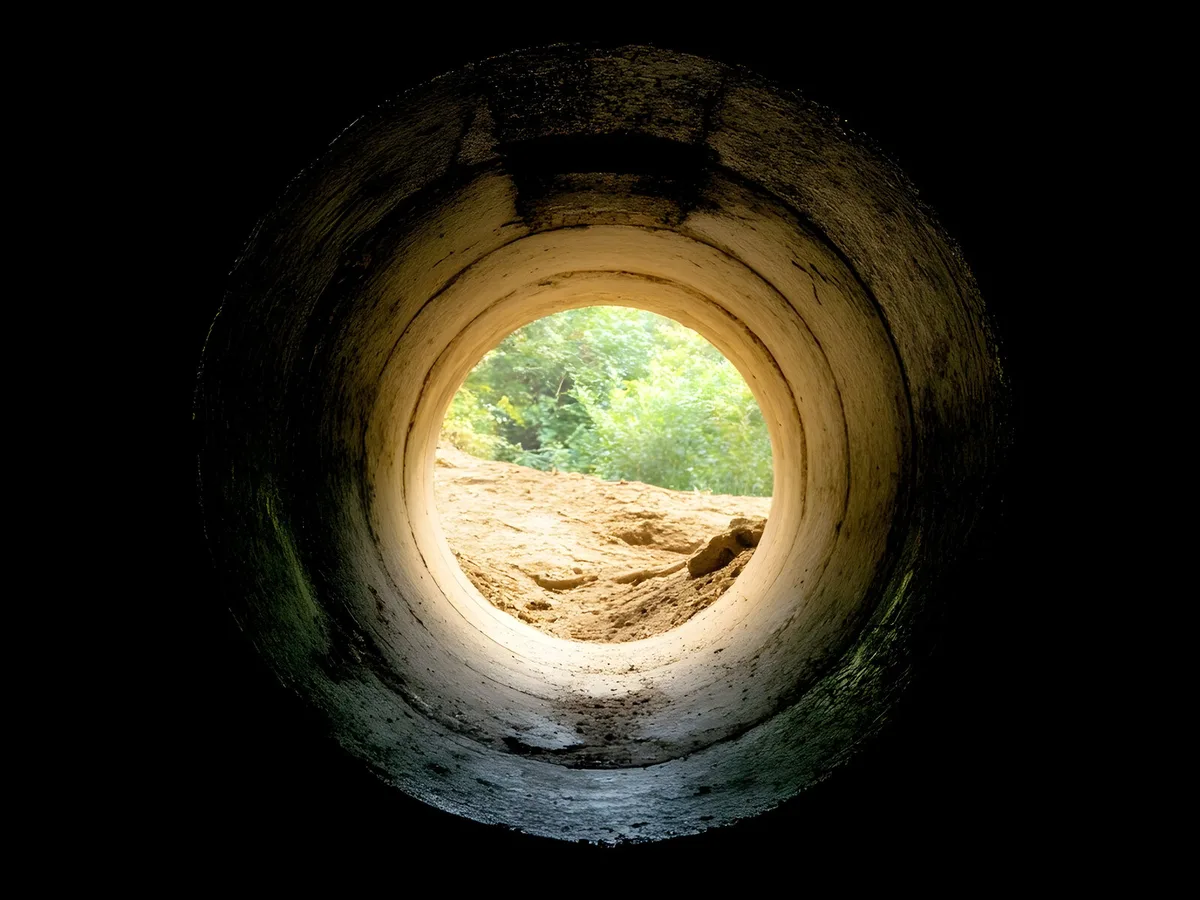 Drain line after epoxy lining — the channel rot is sealed under a smooth, continuous liner
